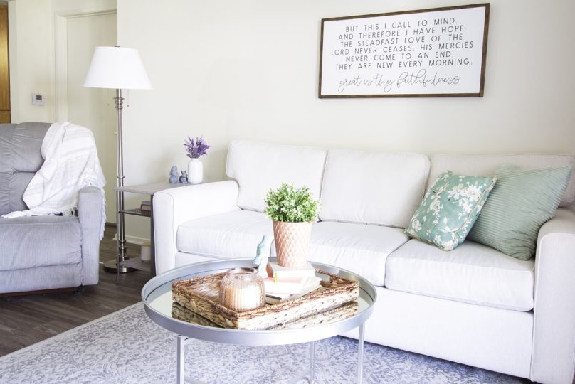 a living room with white furniture and a large picture at The  Collectives